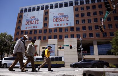 Pedestrians walk past CNN signage ahead of June 27 debate