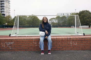 Alex Scott sits on wall