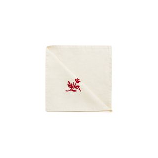 white cotton and linen christmas napkins with a red flower at the center