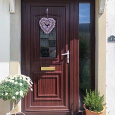 front door with wooden door and flower pot