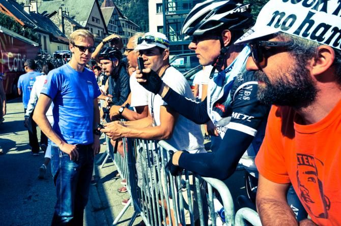 Sports Director Charlie Wegelius stands and chats to fans outside the team bus before the start