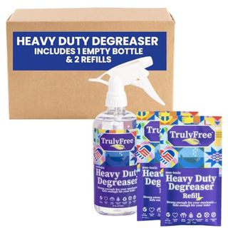 Two blue packets of degreaser next to a matching spray bottle, in front of a cardboard box.