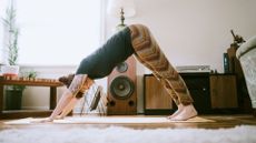 woman doing downward facing dog Pilates move at home