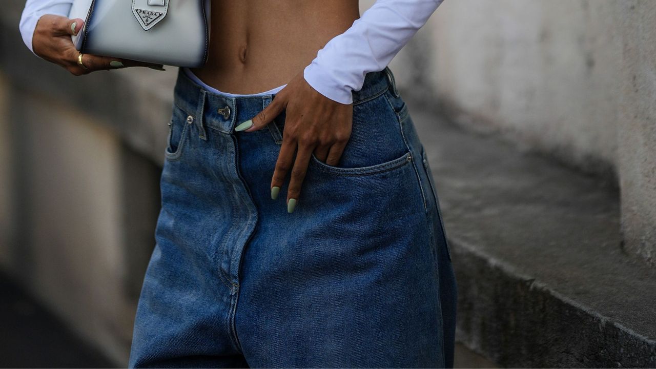 Woman wearing a green nail polish look and a Prada bag