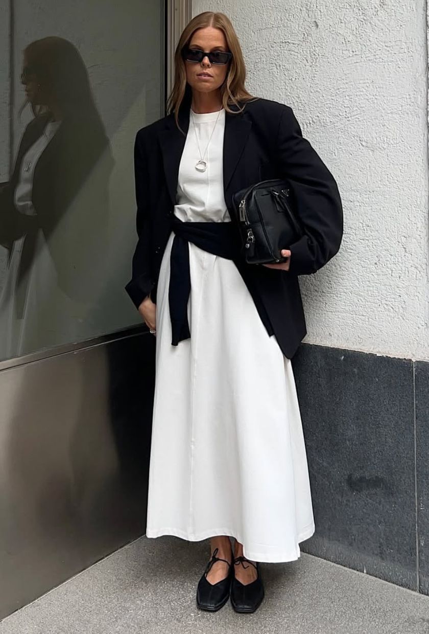 @haaannajohansson wears a black blazer, white midi dress, black flats, a bag and sunglasses