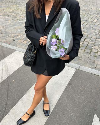 French woman wearing Mary Janes and a miniskirt