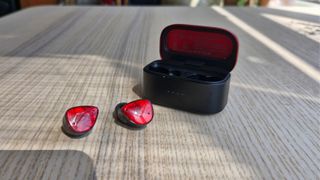 Noble FoKus Amadeus wireless ANC earbuds on a wooden surface