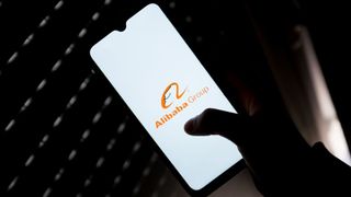 The Alibaba Group logo on a smartphone held by a hand
