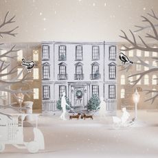 The White Company advent calendar 2026 closed covered with a hand-drawn design and paper cut-out props arranged around it