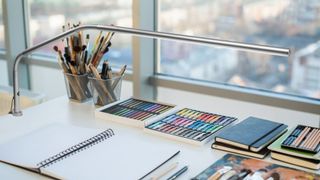 A slim light is attached to an artist's desk