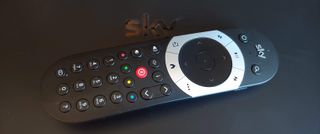 A sky q remote on a black surface