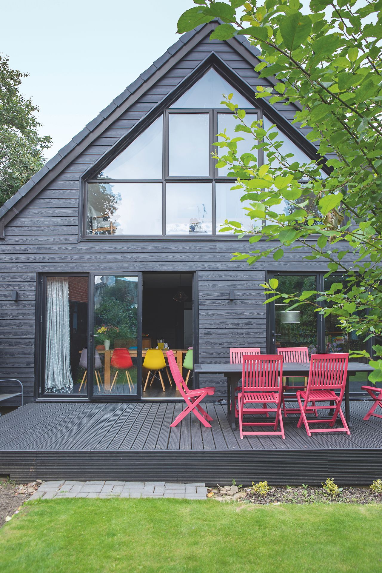 outdoor dining area on black decking next to bungalow
