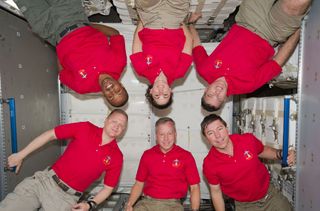 Inside the newly installed Permanent Multipurpose Module (PMM) on the International Space Station are the six crew members of the STS-133 crew.