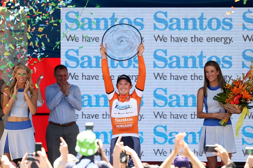 A smiling Simon Gerrans holding the 2014 trophy aloft
