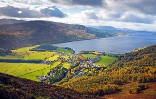 The village of Kinloch Rannoch and Loch Rannoch in the autumn viewed from Craig Varr