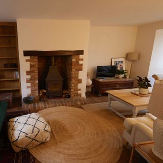 living room with woodturner in fireplace and round jute rug