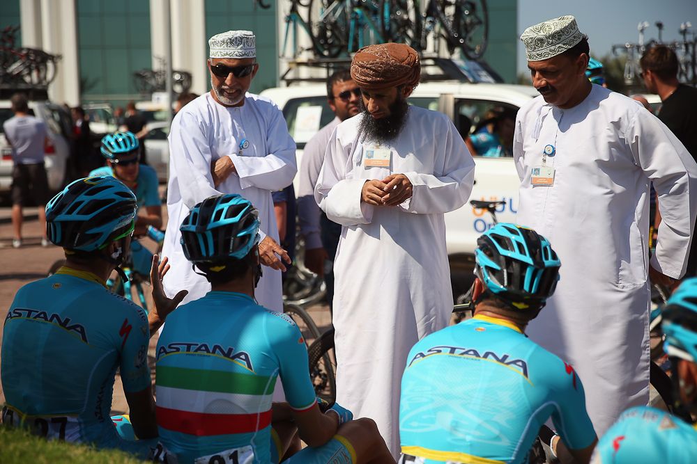 Two local men have their photo taken with the Astana Pro Team at the start of stage two of the 2016 Tour of Oman