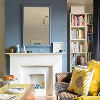 Blue living room with rectangular mirror above the contemporary white fireplace