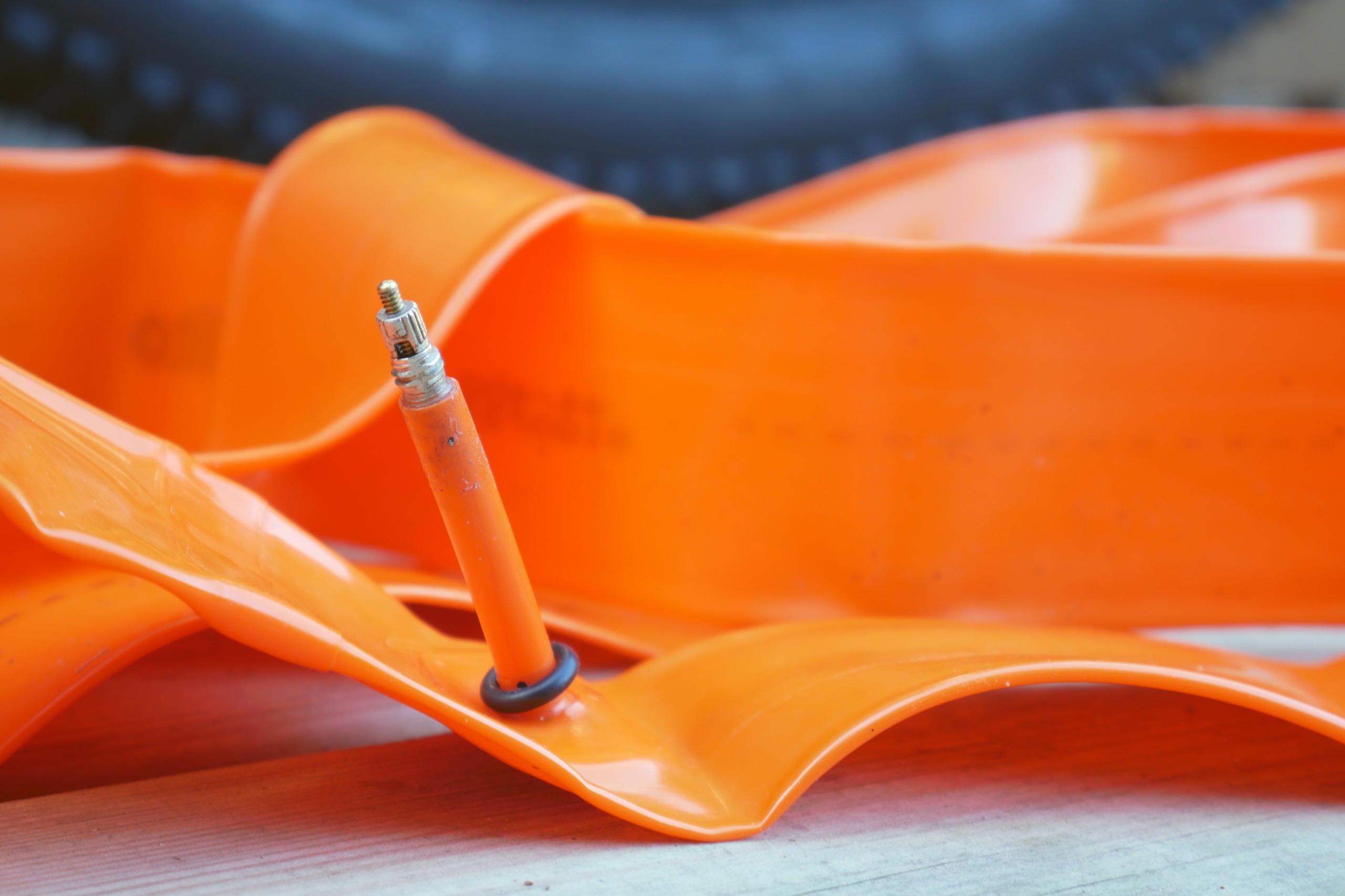 A tubolito TPU inner tube placed on a wooden deck, with a gravel tyre in the background