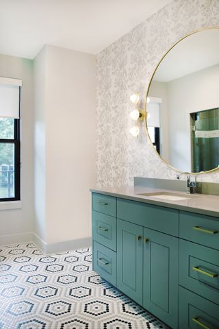 Bathroom with green vanity and mosaic floor tiles