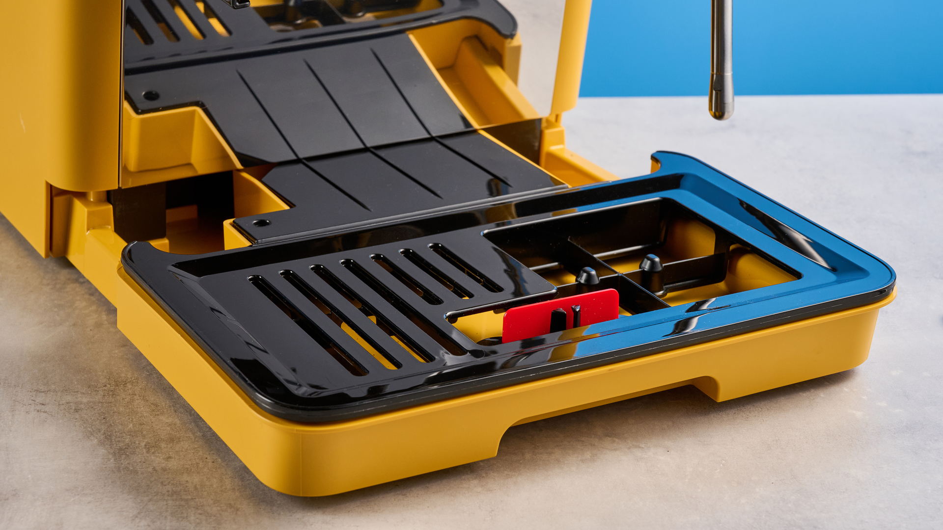 the de&#039;longhi la specialista arte evo special edition truestart edition, with yellow body, showing the espresso machine attachments like tamper, tamping collar, grinder, and control buttons