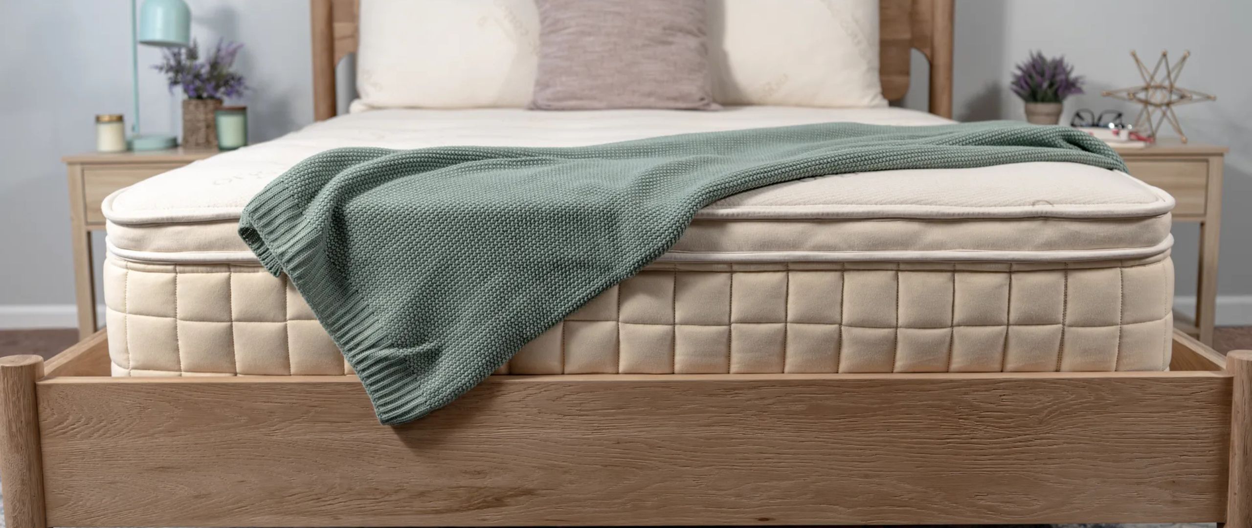 The Naturepedic Concerto Pillow Top mattress on a wooden bed frame