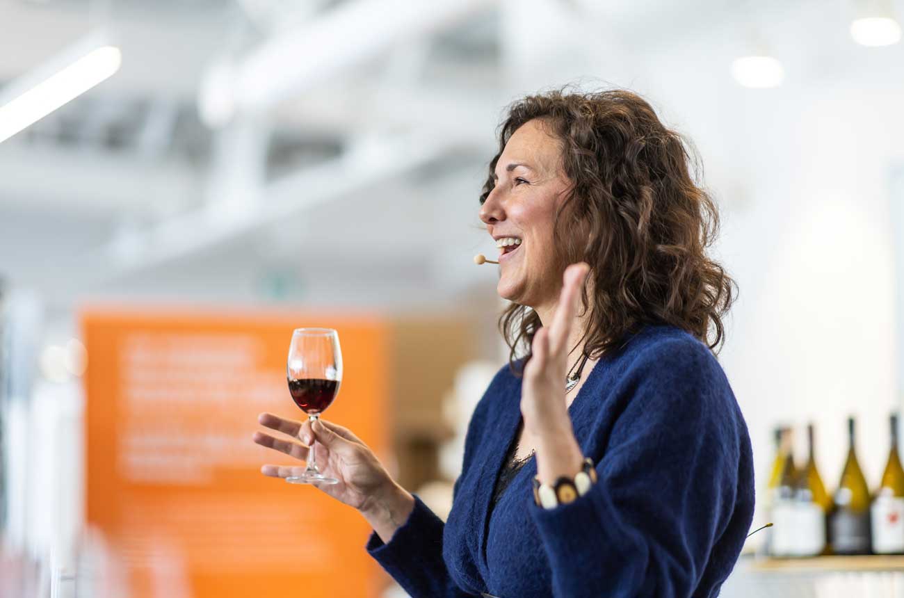 Image of author and speaker Elaine Chukan Brown holding a wine glass.