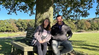 Angela Hannibal and Nick Knowles sit under a tree in DIY SOS: EastEnders