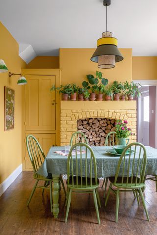 Yellow dining room with green dining table and chairs