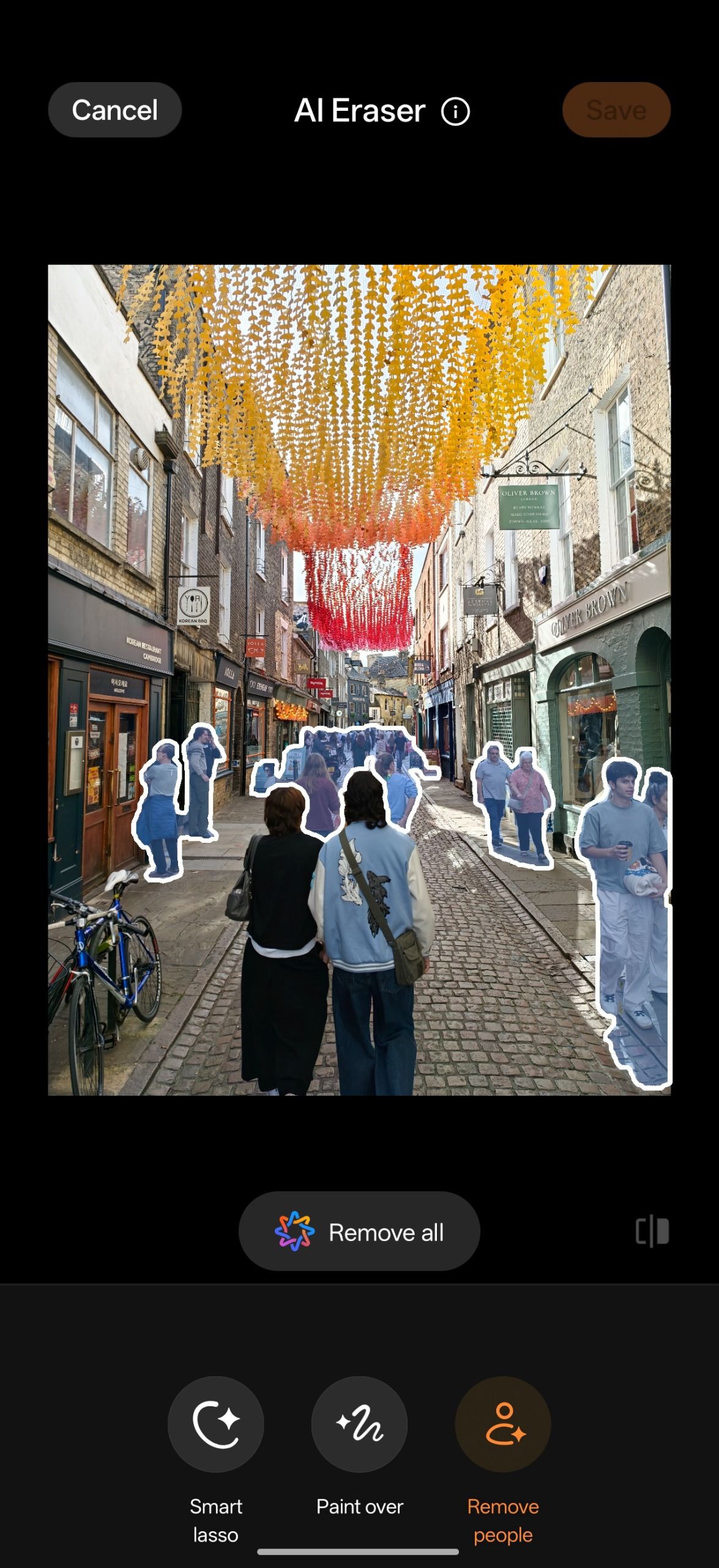 AI Eraser interface highlighting groups of people for removal from a busy street photo.