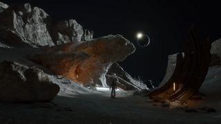 A person in a space suit walks through a lunar canyon as the Earth eclipses the sun