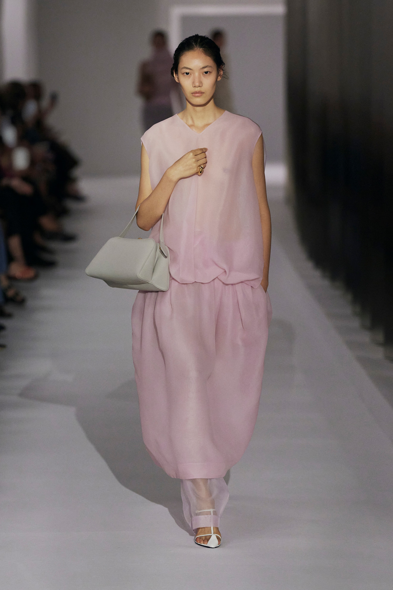 Khaite model walks the spring/summer 2025 runway carrying a frame bag