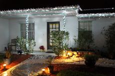 A front yard decorated with Christmas lights