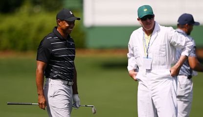 Woods chats with his caddie during a practice round at The Masters