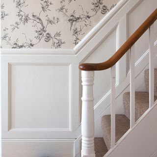 hallway area with floral wallpaper and staircase