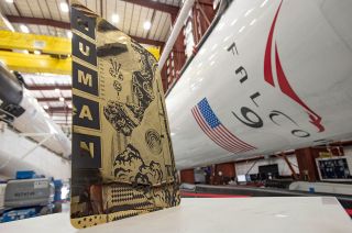 Tristan Eaton's "Human Kind" artwork, seen beside SpaceX Falcon 9 rockets at NASA's Kennedy Space Center in Florida, is launching on SpaceX's first crewed mission to the International Space Station.