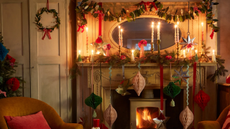 a holiday mantel decorated with various types of garland and paper Christmas decor 