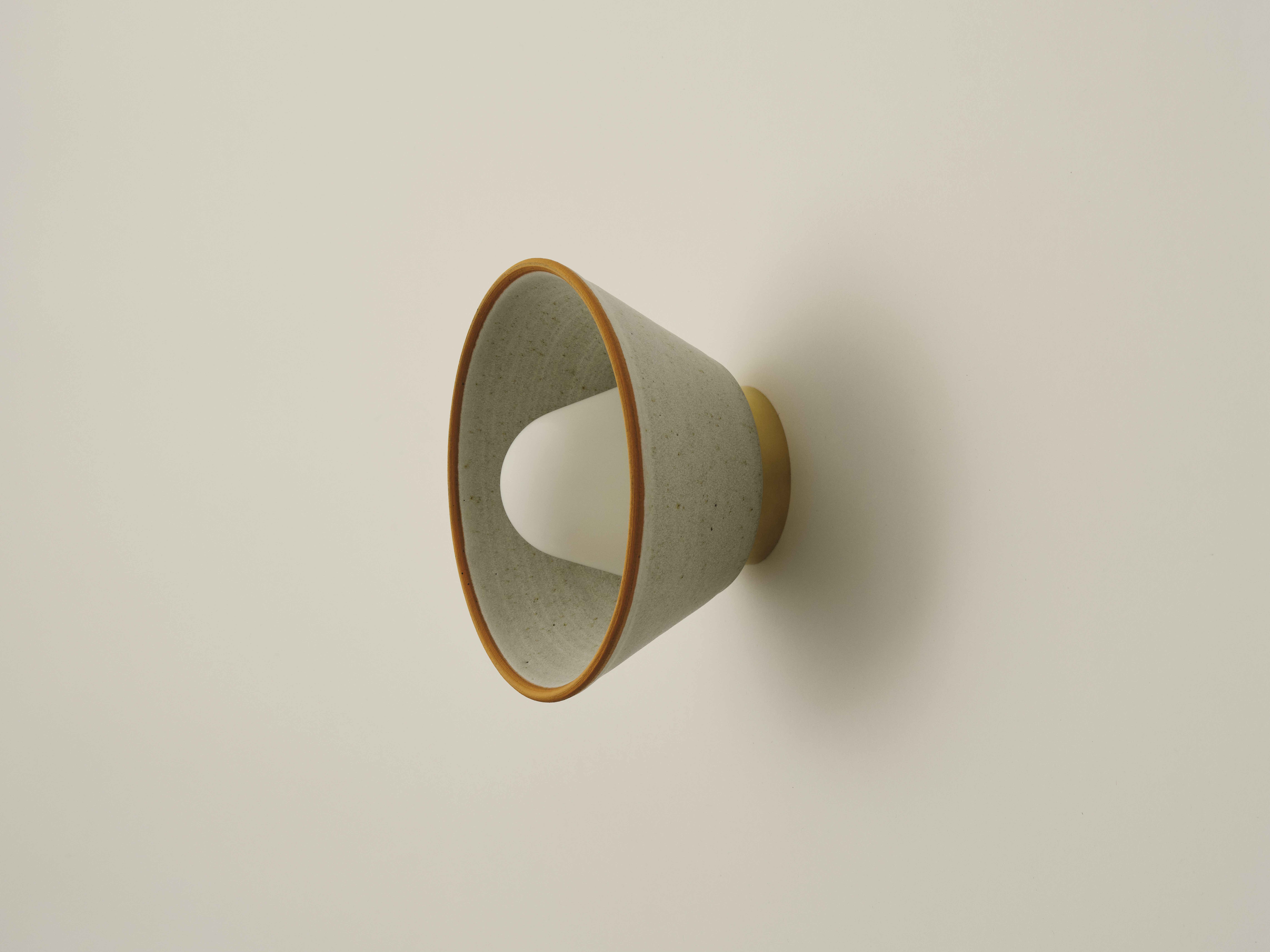 Stoneware wall lamp on a grey wall