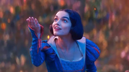 Rachel Zegler's Snow White holding up her right hand in her self-titled live-action movie adaptation