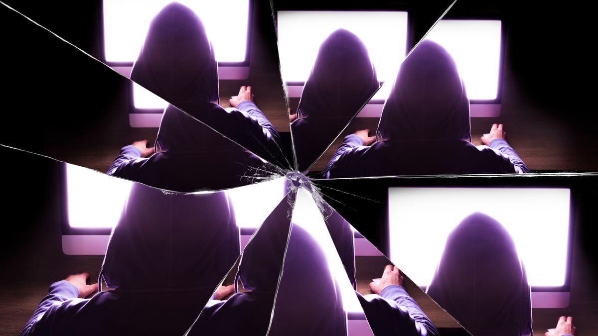 The reflection of a hacker seen in a broken mirror to represent identity-based cyber attacks