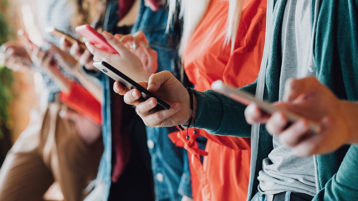 A cropped close up of young people holding mobile phones.