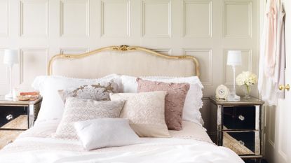 Pretty pink bedroom with upholstered cream and gold headboard 
