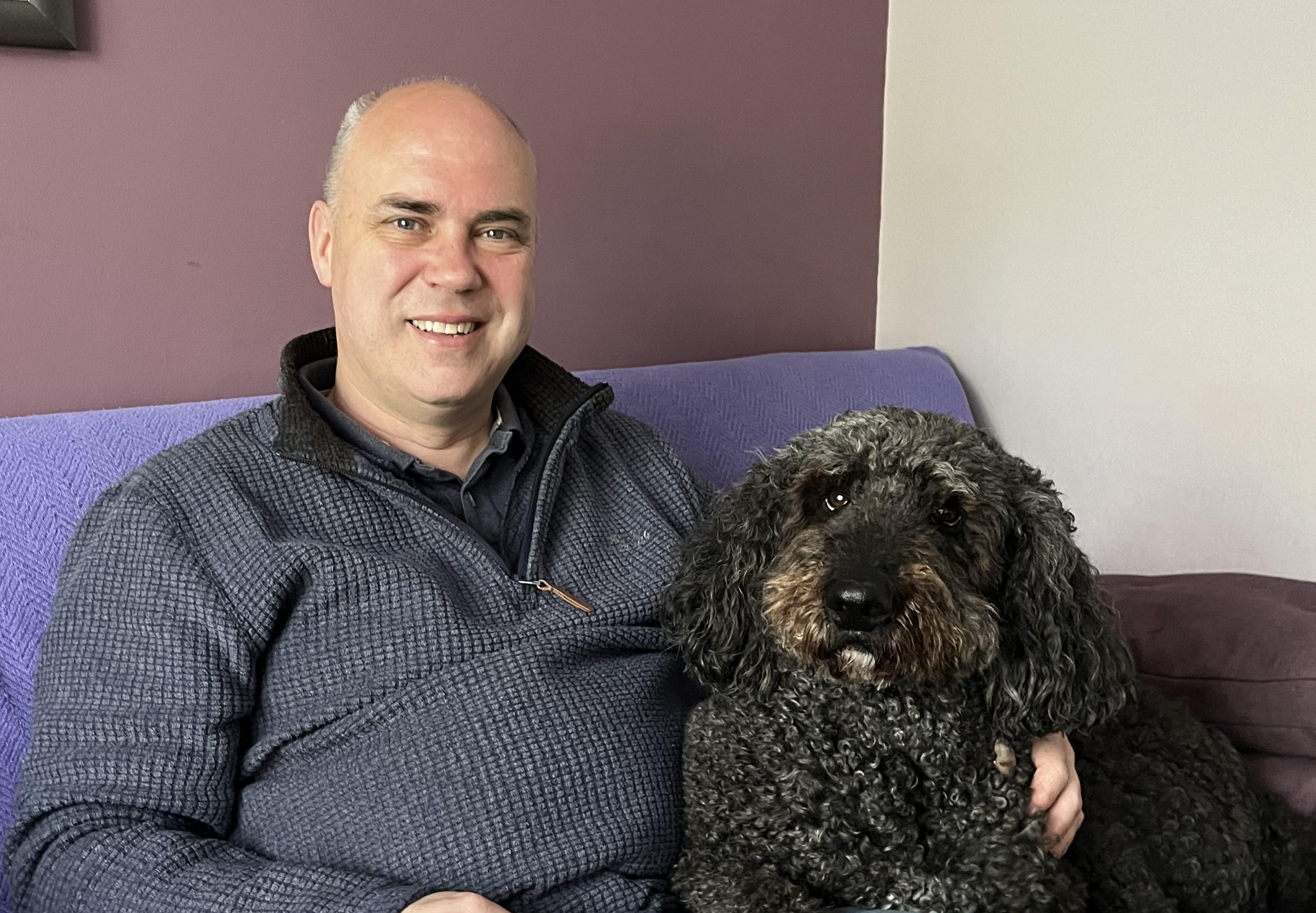 John Middleton sits beside dog in photo