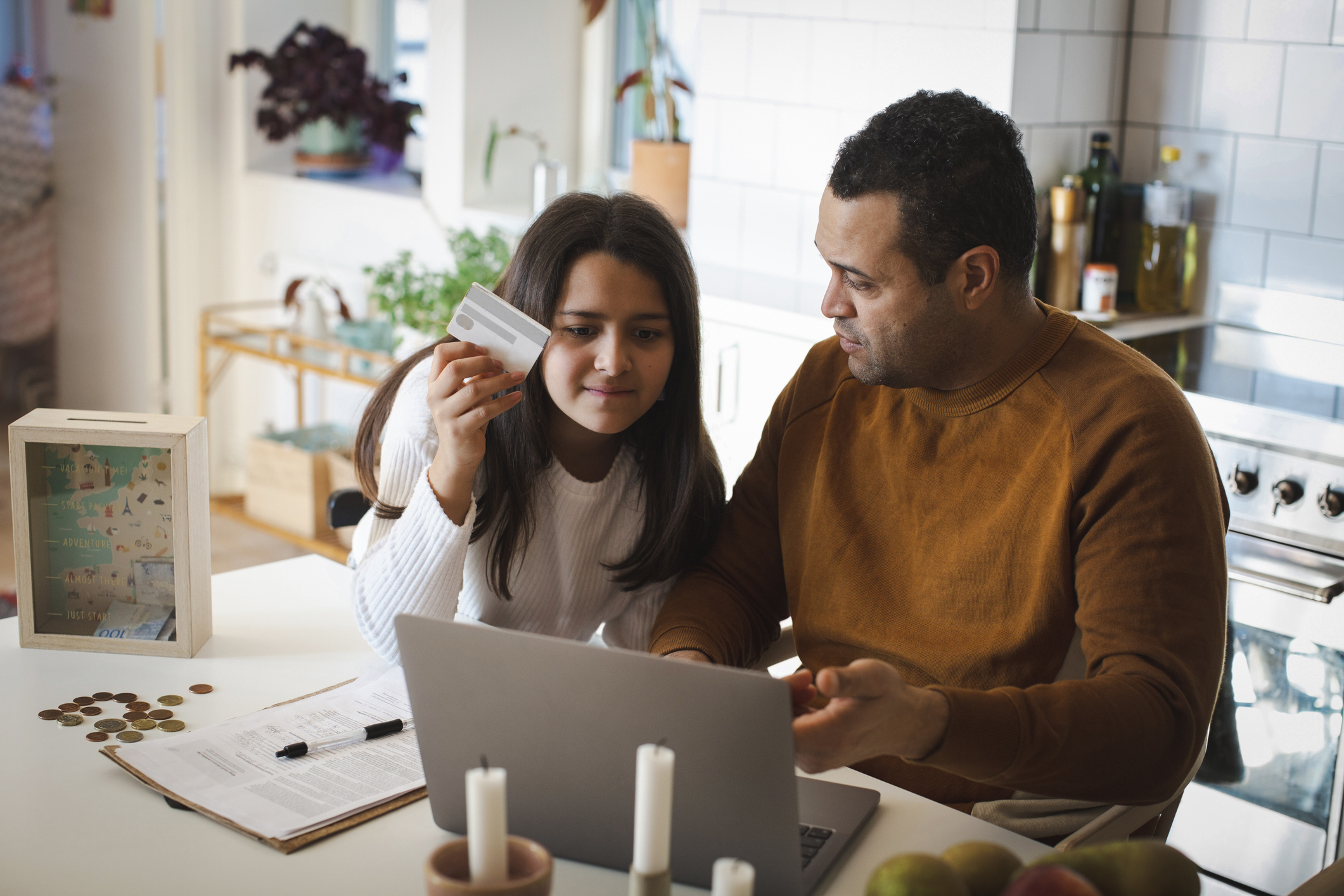 Parent and child looking at laptop with credit card