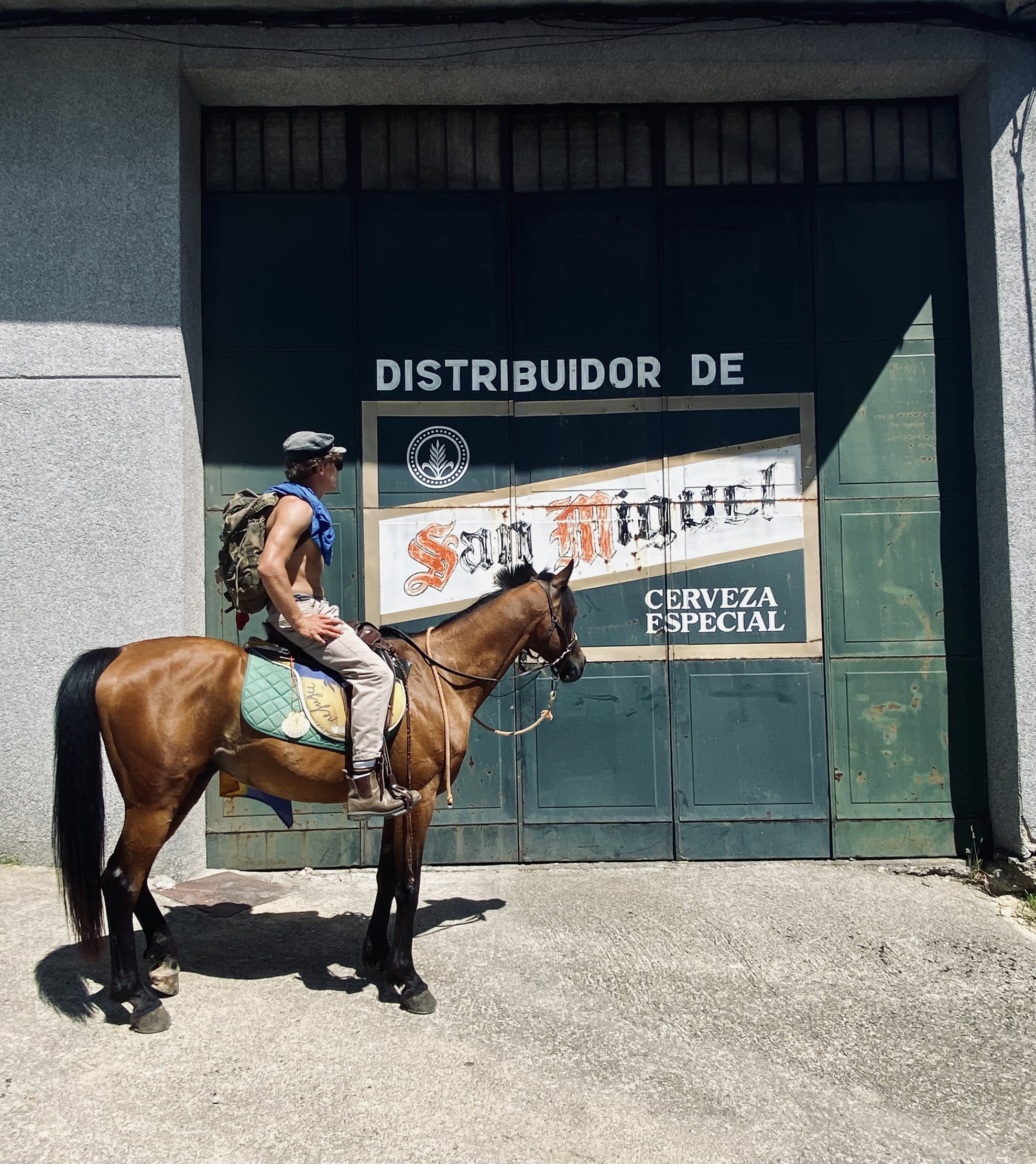 Louis D Hall on horseback looking at a sign that says San Miguel
