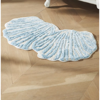 seashell-shaped rug with tufted blue line detail