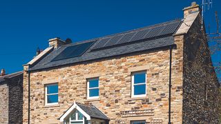 stone clad self build with solar thermal and solar pv panels on roof