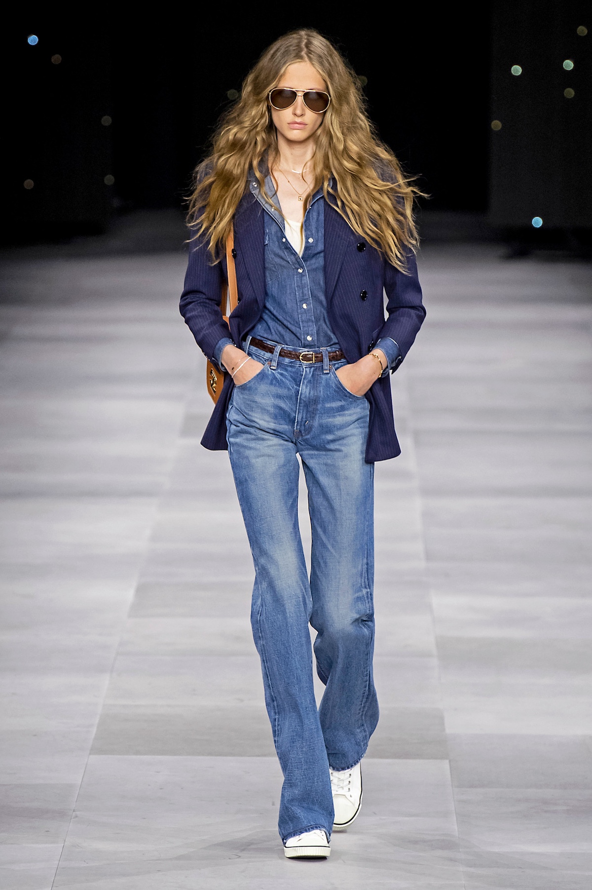 runway shot of Celine Ready to Wear Spring Summer 2020 with a blue blazer, denim shirt, flared jeans, and sneakers