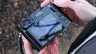 The back of a Leica Q3 43 camera held in a person's hands