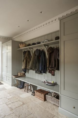 bespoke painted bootroom with fitted cupboards, storage bench and coat hooks by artichoke
